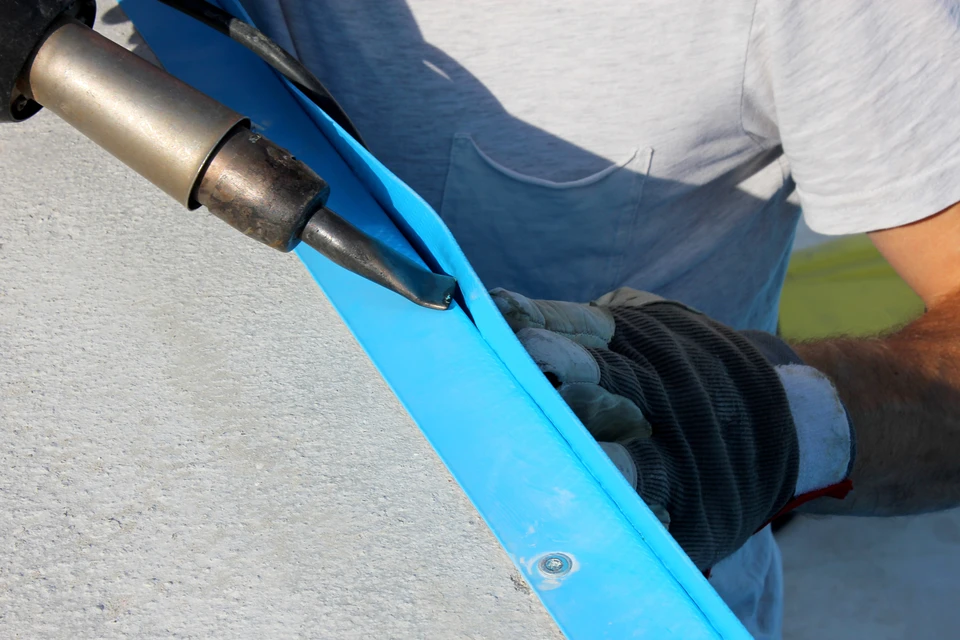 Pose de membrane d'étanchéité bleue sur toiture-terrasse en extérieur
