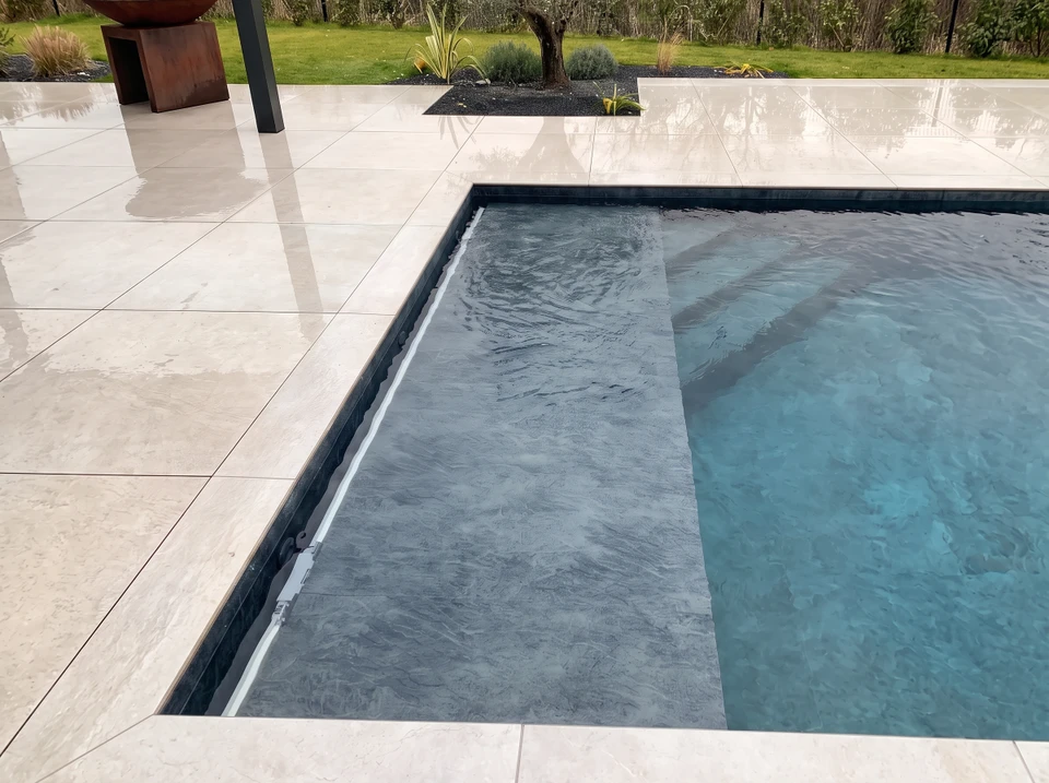 Pose d'un liner PVC gris anthracite dans une piscine vide à forme libre